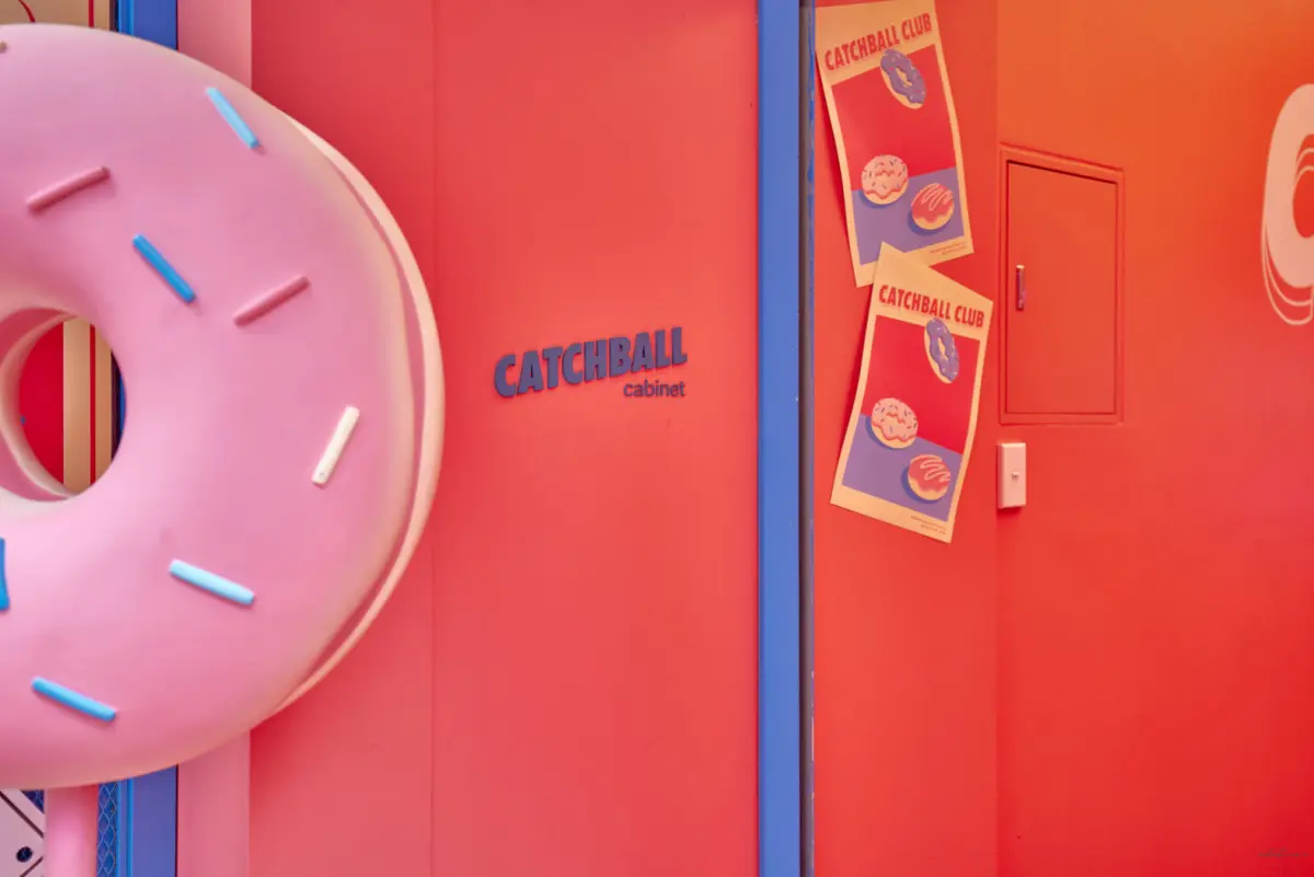 코랄 핑크 벽면과 도넛 조형물의 팝아트 인테리어